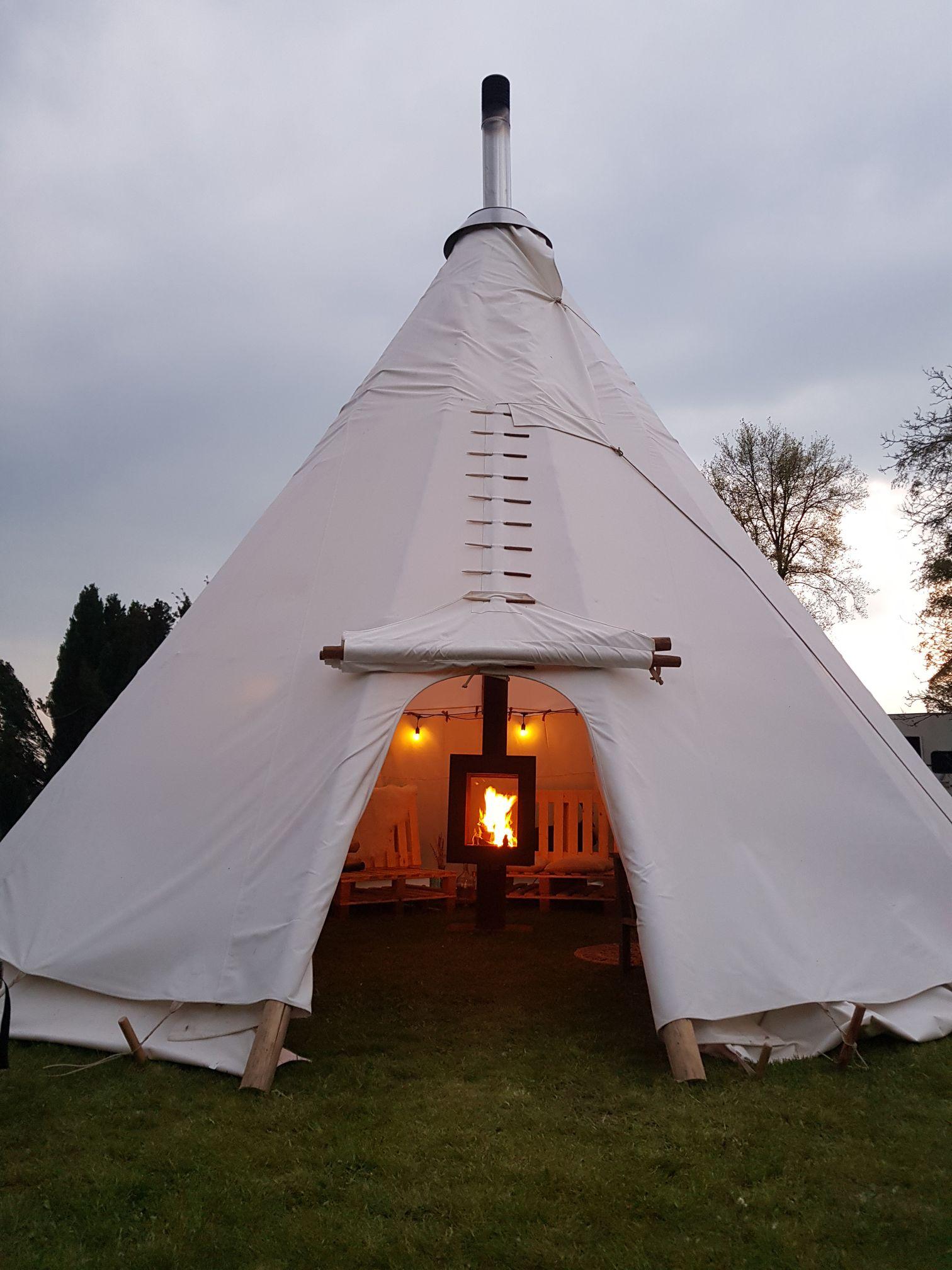 Woodchuck Tipi avec la porte ouverte et vue sur le poêle à bois sans fumée