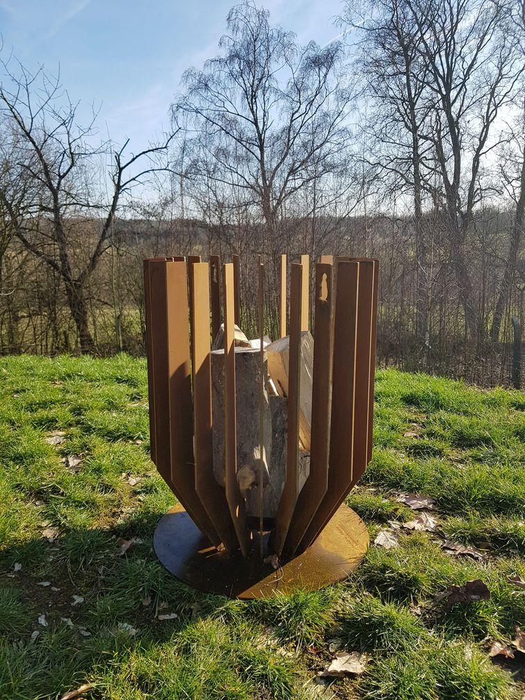 Woodchuck V grote stalen vuurkorf, voorgeroest en gevuld met hout.